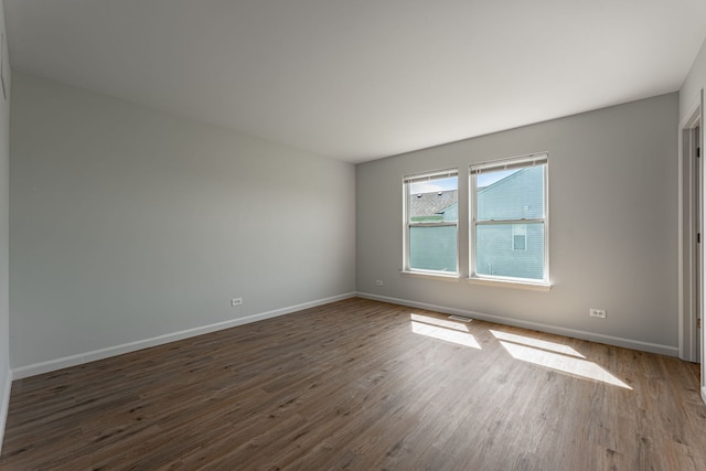 spare room with dark wood finished floors and baseboards