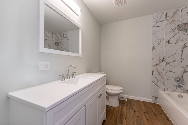 full bath with visible vents, toilet, wood finished floors, vanity, and shower / washtub combination