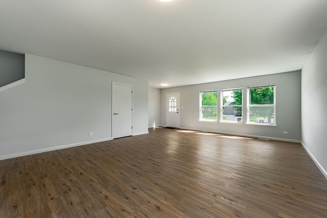 unfurnished living room with dark wood-style floors and baseboards