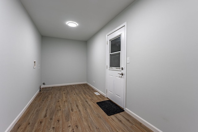 doorway featuring visible vents, baseboards, and wood finished floors