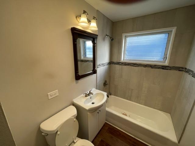 full bathroom featuring washtub / shower combination, vanity, toilet, and wood finished floors