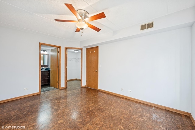 spare room with ceiling fan, a textured ceiling, visible vents, and baseboards