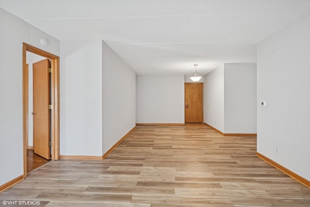 empty room with light wood-style floors and baseboards