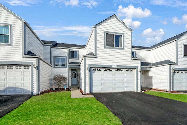 view of front facade with a garage, driveway, and a front lawn