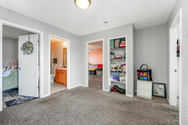 bedroom featuring light carpet, baseboards, and ensuite bathroom