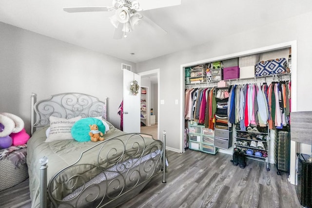 bedroom featuring a ceiling fan, a closet, visible vents, and wood finished floors