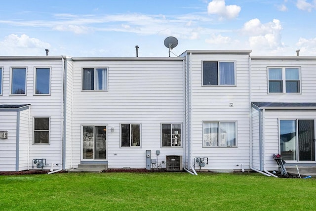 back of house featuring central air condition unit, entry steps, and a yard