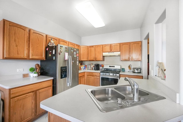 kitchen featuring a peninsula, stainless steel appliances, light countertops, under cabinet range hood, and a sink