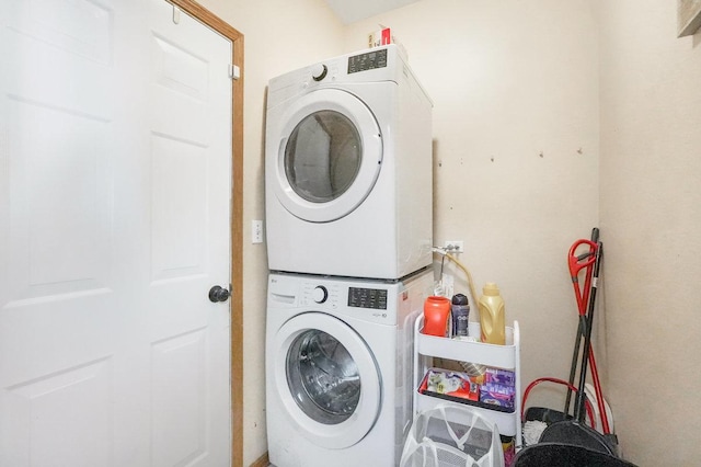 washroom with stacked washer / drying machine and laundry area