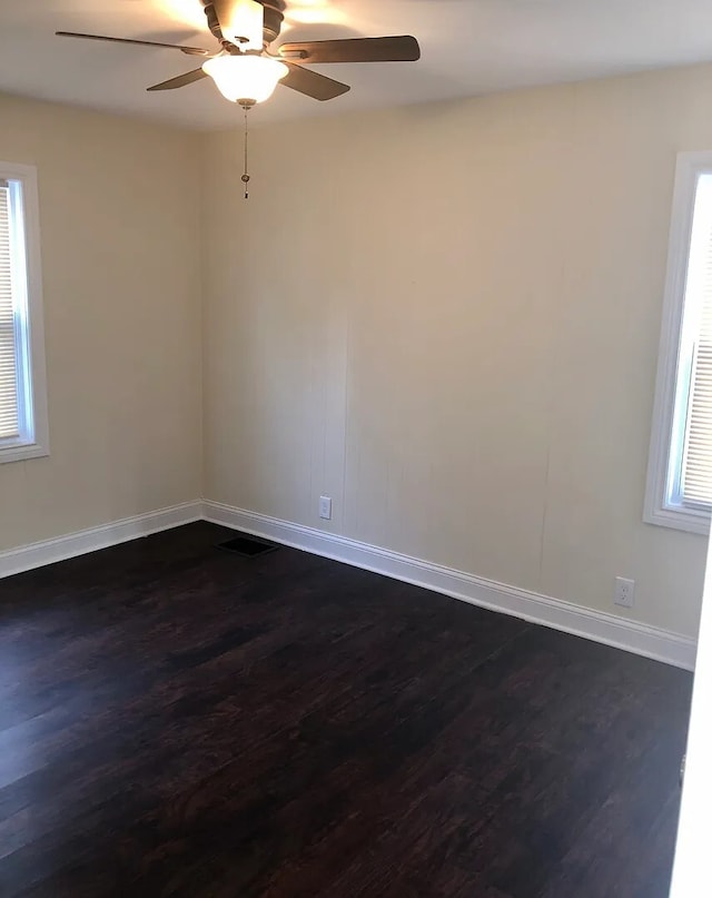 unfurnished room with dark wood finished floors, baseboards, and ceiling fan