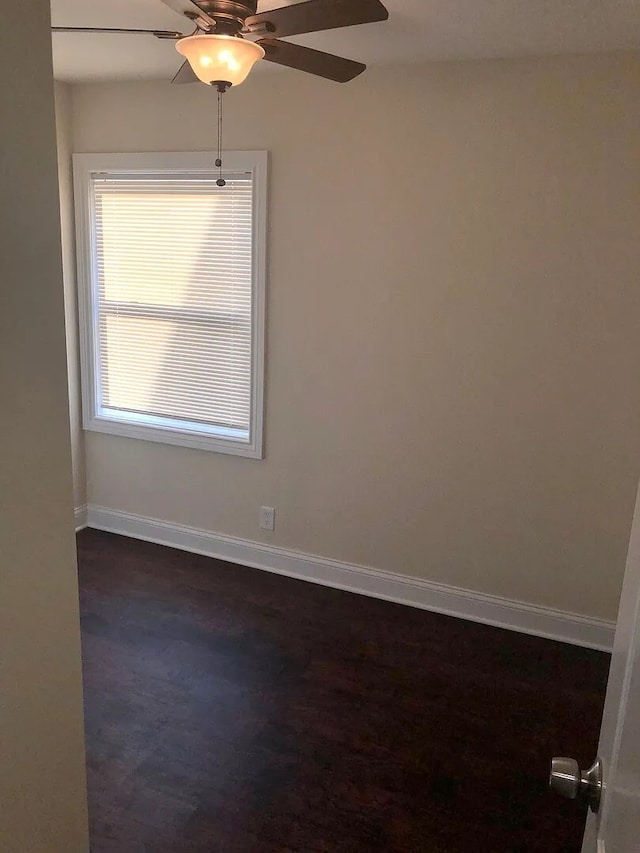 spare room featuring a ceiling fan and baseboards