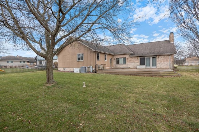 back of property featuring brick siding, a yard, a chimney, fence, and cooling unit