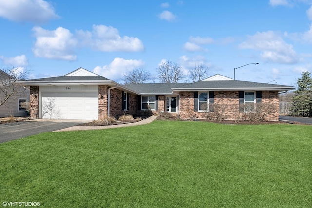 ranch-style home with driveway, a shingled roof, a front yard, an attached garage, and brick siding