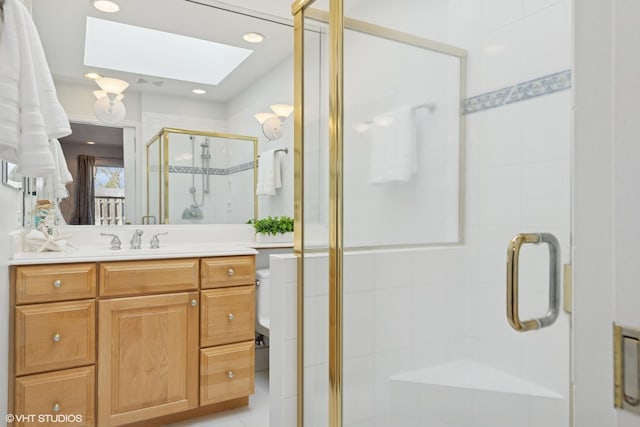 full bathroom featuring recessed lighting, a shower stall, a skylight, and vanity