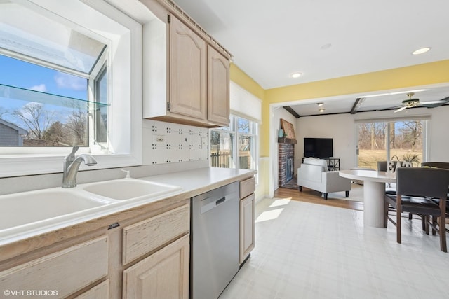 kitchen with light brown cabinetry, a sink, plenty of natural light, light countertops, and dishwasher