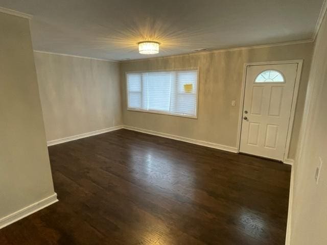 entrance foyer with plenty of natural light, baseboards, dark wood-style flooring, and crown molding