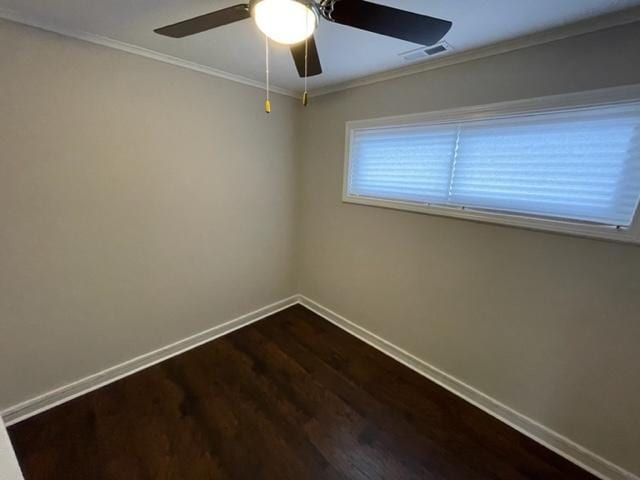 unfurnished room with dark wood-style floors, crown molding, visible vents, a ceiling fan, and baseboards