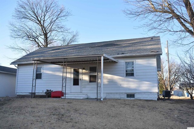 rear view of house featuring entry steps, roof with shingles, a lawn, and central air condition unit