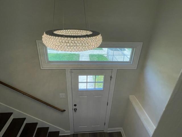 entryway with stairway, baseboards, and wood finished floors