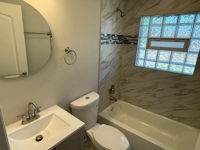 full bathroom with shower / bathing tub combination, vanity, and toilet