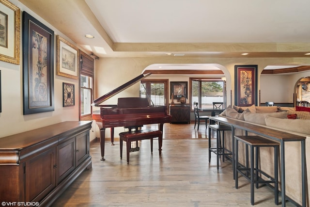 interior space featuring arched walkways, baseboards, recessed lighting, and wood finished floors