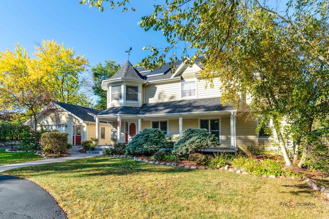 victorian-style house featuring a front lawn and a porch