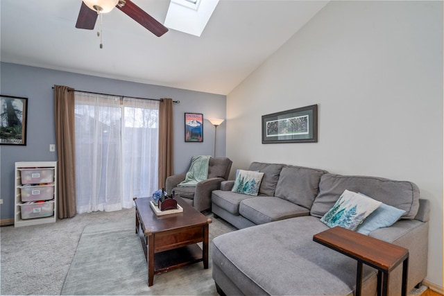 living room featuring light carpet, high vaulted ceiling, a skylight, and a ceiling fan