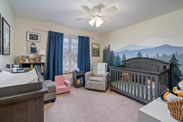 bedroom featuring carpet floors, a crib, a fireplace, and a ceiling fan