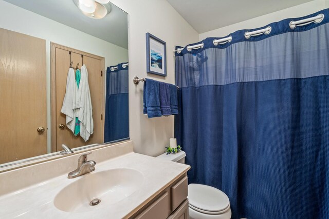 full bath with toilet, a shower with shower curtain, and vanity