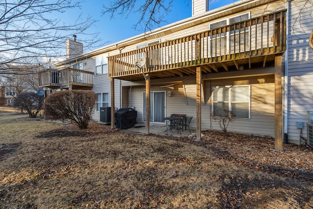 rear view of house with a patio area, a chimney, and central AC unit