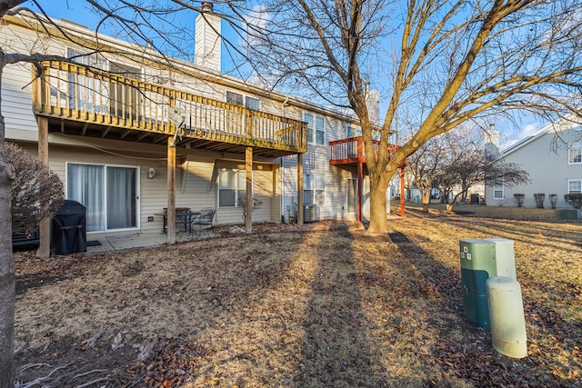 back of property featuring a chimney and central air condition unit