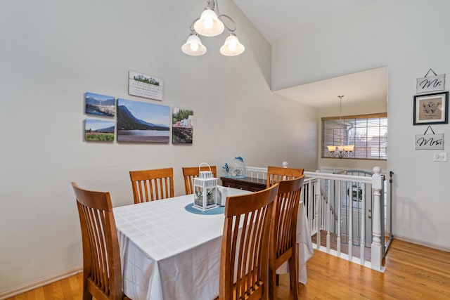 dining room with wood finished floors, baseboards, and an inviting chandelier