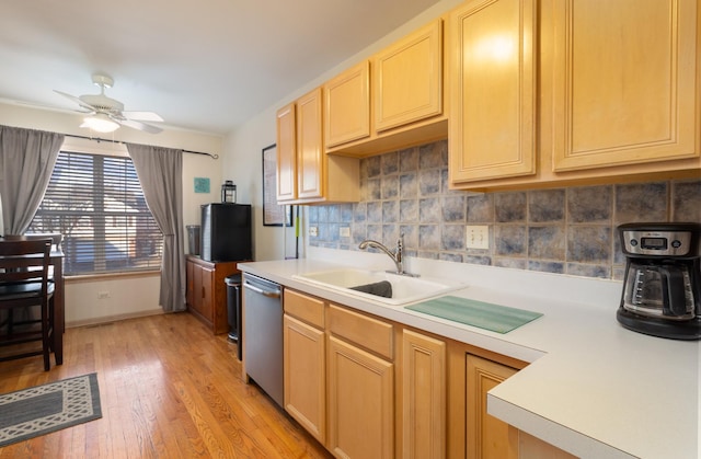 kitchen with light countertops, dishwasher, a sink, and light brown cabinetry