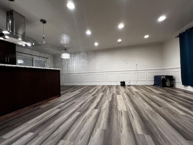 interior space featuring a decorative wall, dark wood-style flooring, wainscoting, and recessed lighting