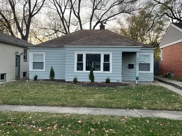 bungalow with a front lawn and a chimney