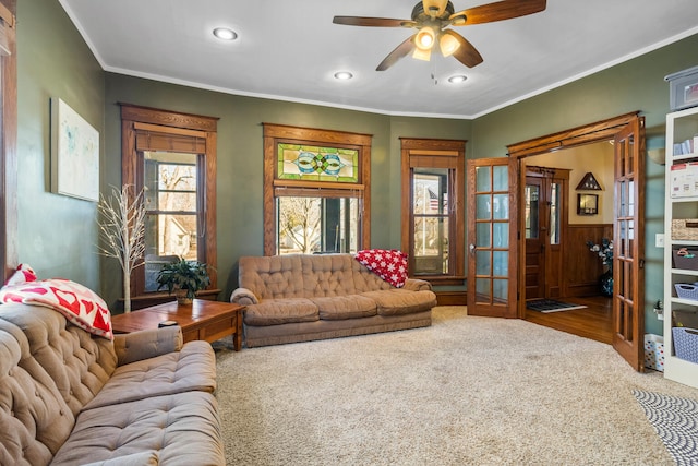 living room featuring recessed lighting, a wainscoted wall, carpet flooring, a ceiling fan, and crown molding