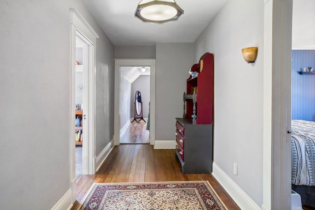 hall with baseboards and hardwood / wood-style floors