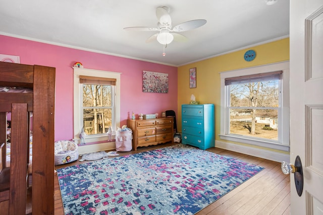 bedroom with wood-type flooring, a ceiling fan, and crown molding