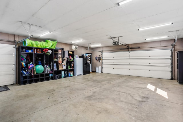 garage featuring a garage door opener and freestanding refrigerator