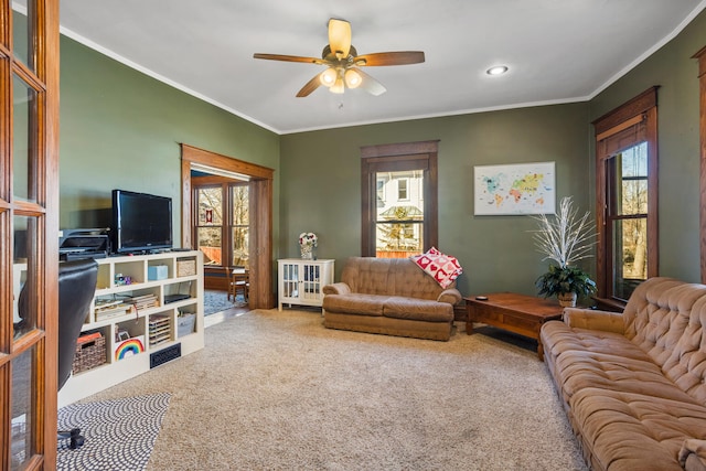 living area featuring ceiling fan, a wealth of natural light, and crown molding