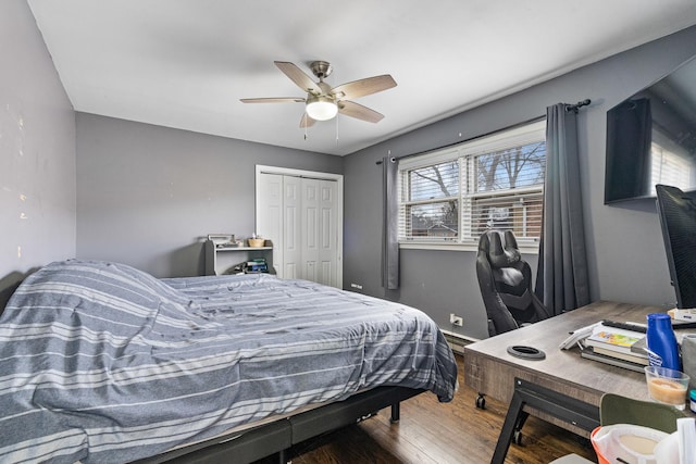 bedroom featuring ceiling fan, a closet, and wood finished floors