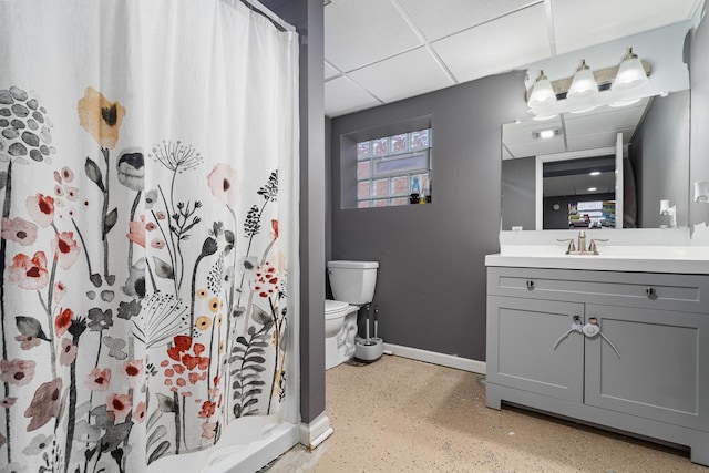 bathroom featuring a drop ceiling, toilet, vanity, baseboards, and a shower with curtain