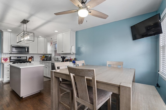 kitchen with dark wood-type flooring, a sink, white cabinets, appliances with stainless steel finishes, and backsplash