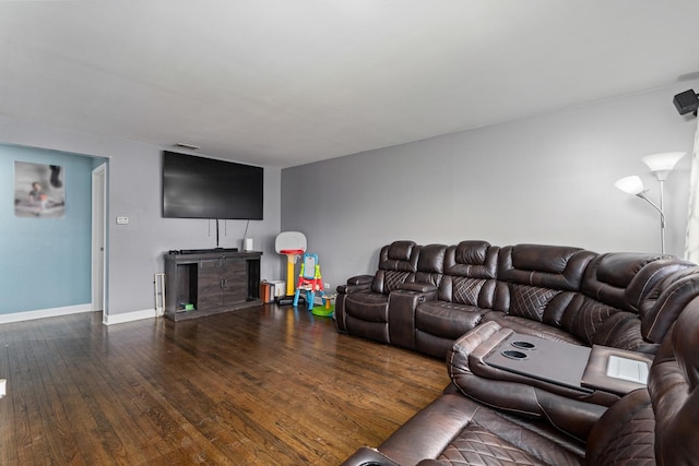living room featuring visible vents, hardwood / wood-style flooring, and baseboards