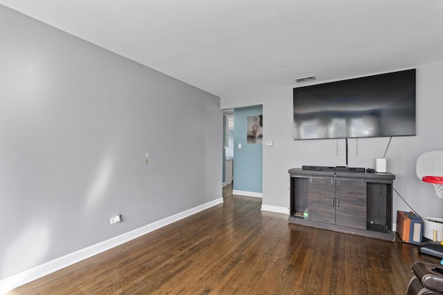 living area featuring visible vents, baseboards, and wood finished floors
