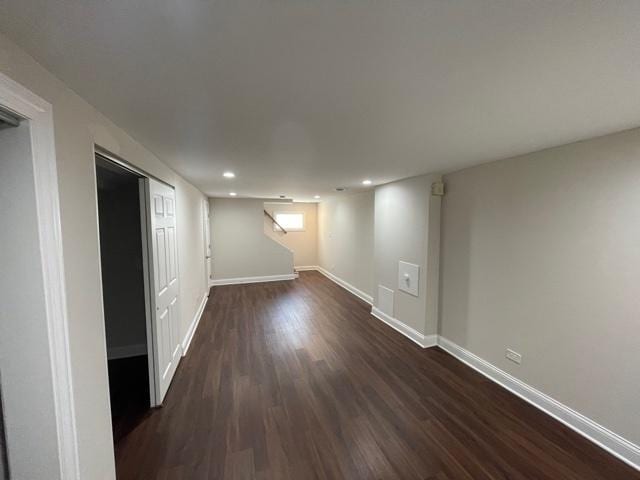 below grade area featuring dark wood-type flooring, recessed lighting, visible vents, and baseboards