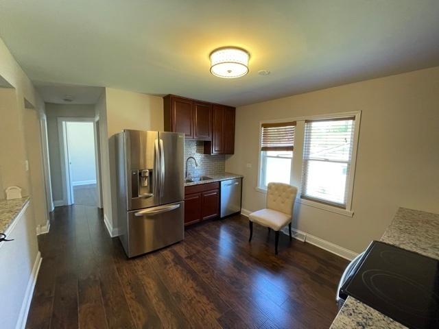 kitchen with stainless steel fridge, dishwasher, electric stove, dark wood-style floors, and a sink