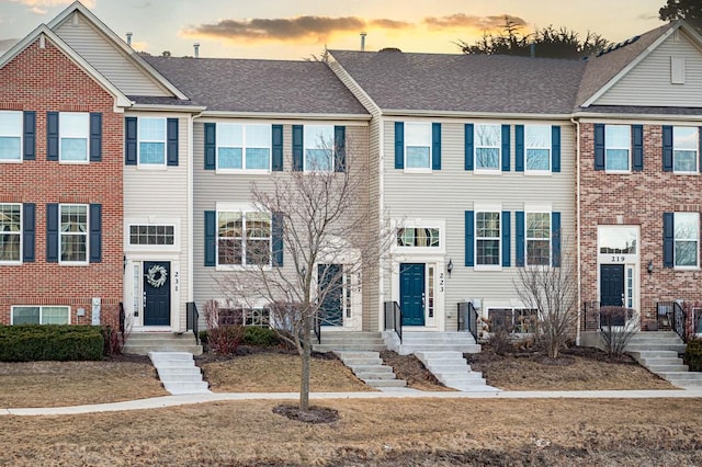 townhome / multi-family property featuring roof with shingles