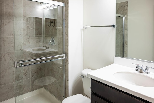 bathroom with toilet, a stall shower, and vanity