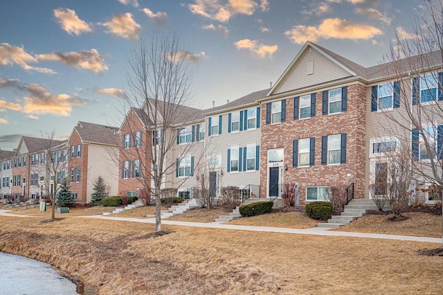 view of property featuring a residential view and brick siding